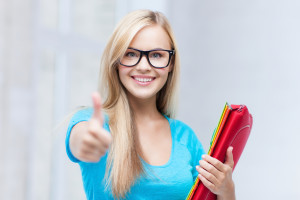 picture of smiling student with folders showing thumbs up